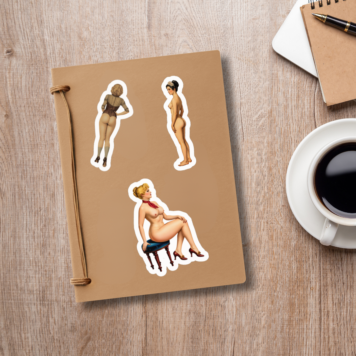 Notebook with stickers of women on a wooden surface with a cup of coffee.