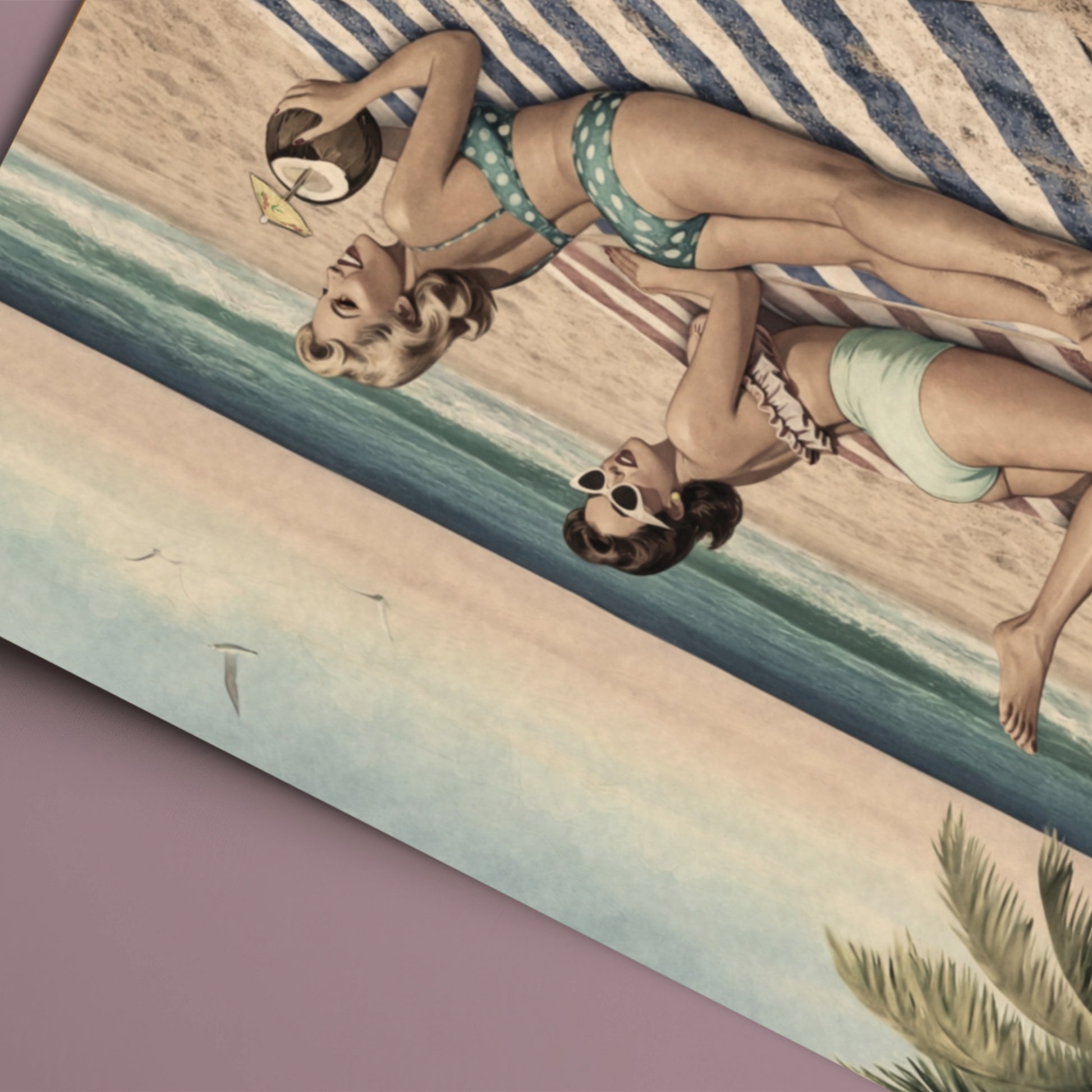 Two women in vintage swimwear lying on a striped towel with a beach scene.