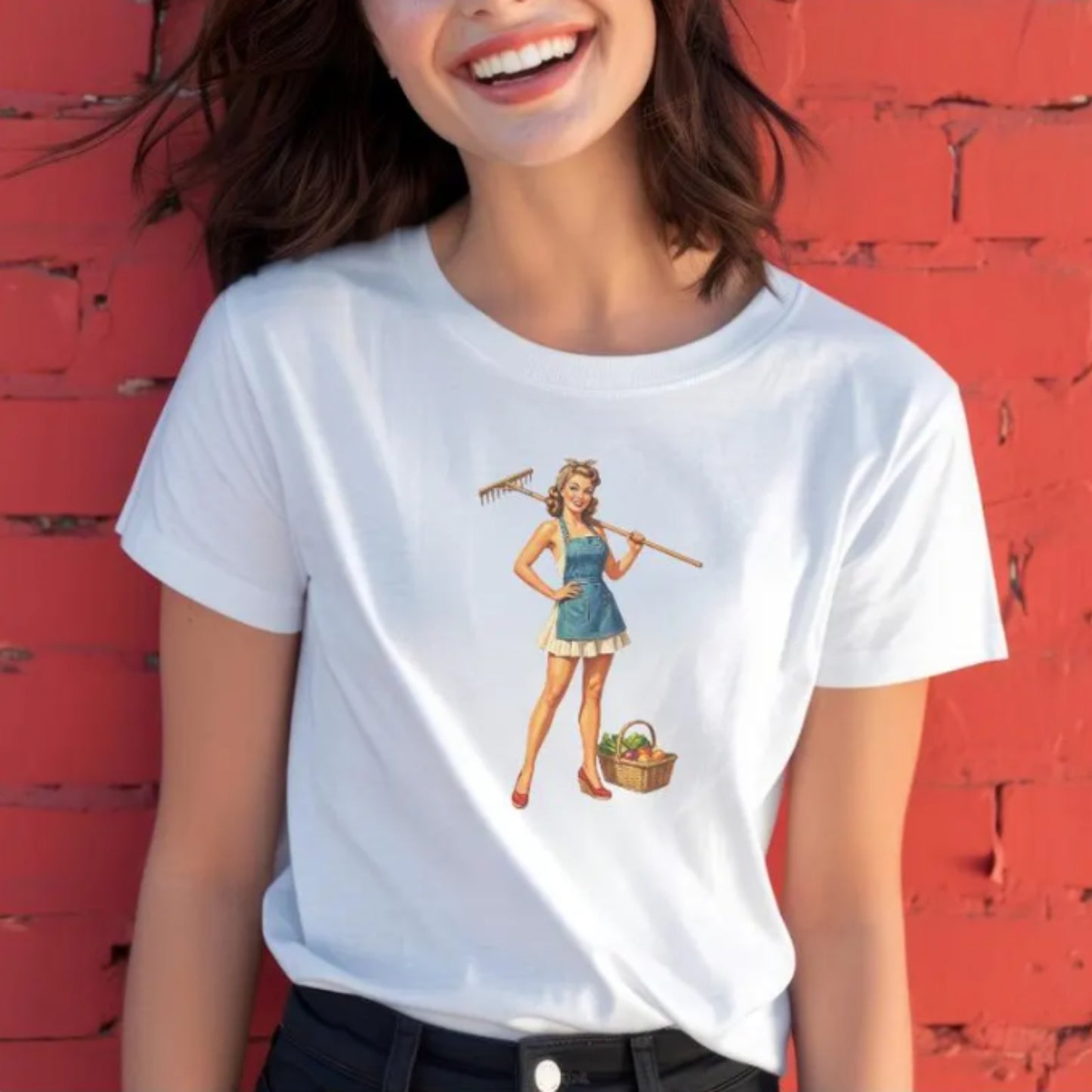 Person wearing a white t-shirt with a graphic design against a red brick wall.