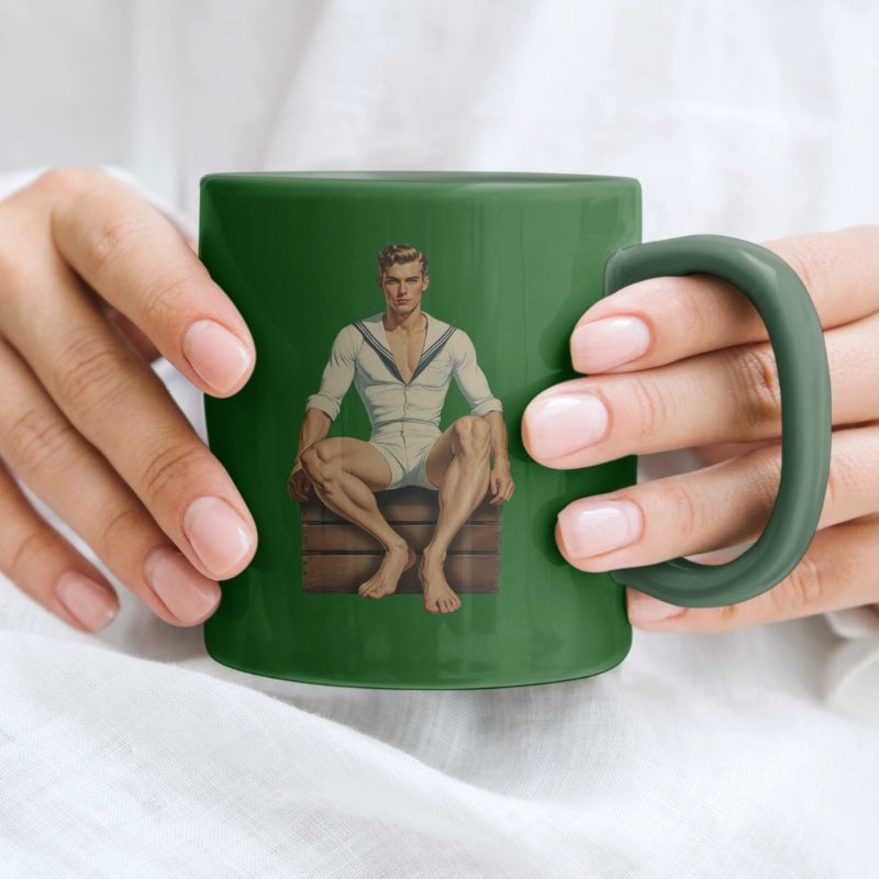 Green mug with a graphic of a man in a sailor outfit held by two hands.