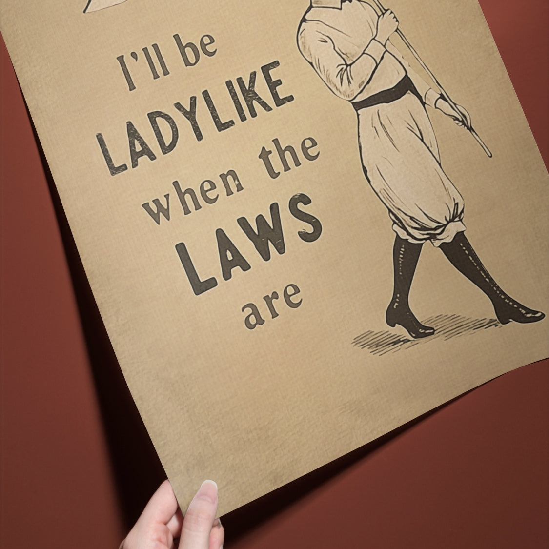 Poster with text 'I'll be LADYLIKE when the LAWS are' and a vintage-style illustration of a woman holding a club.