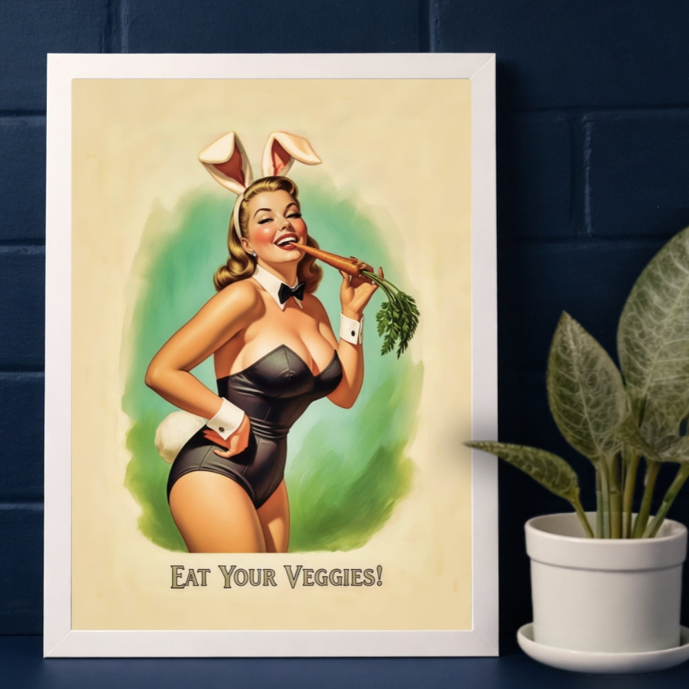 Framed poster of a woman in bunny ears holding a carrot with 'Eat Your Veggies!' text, placed on a dark blue surface with a plant.