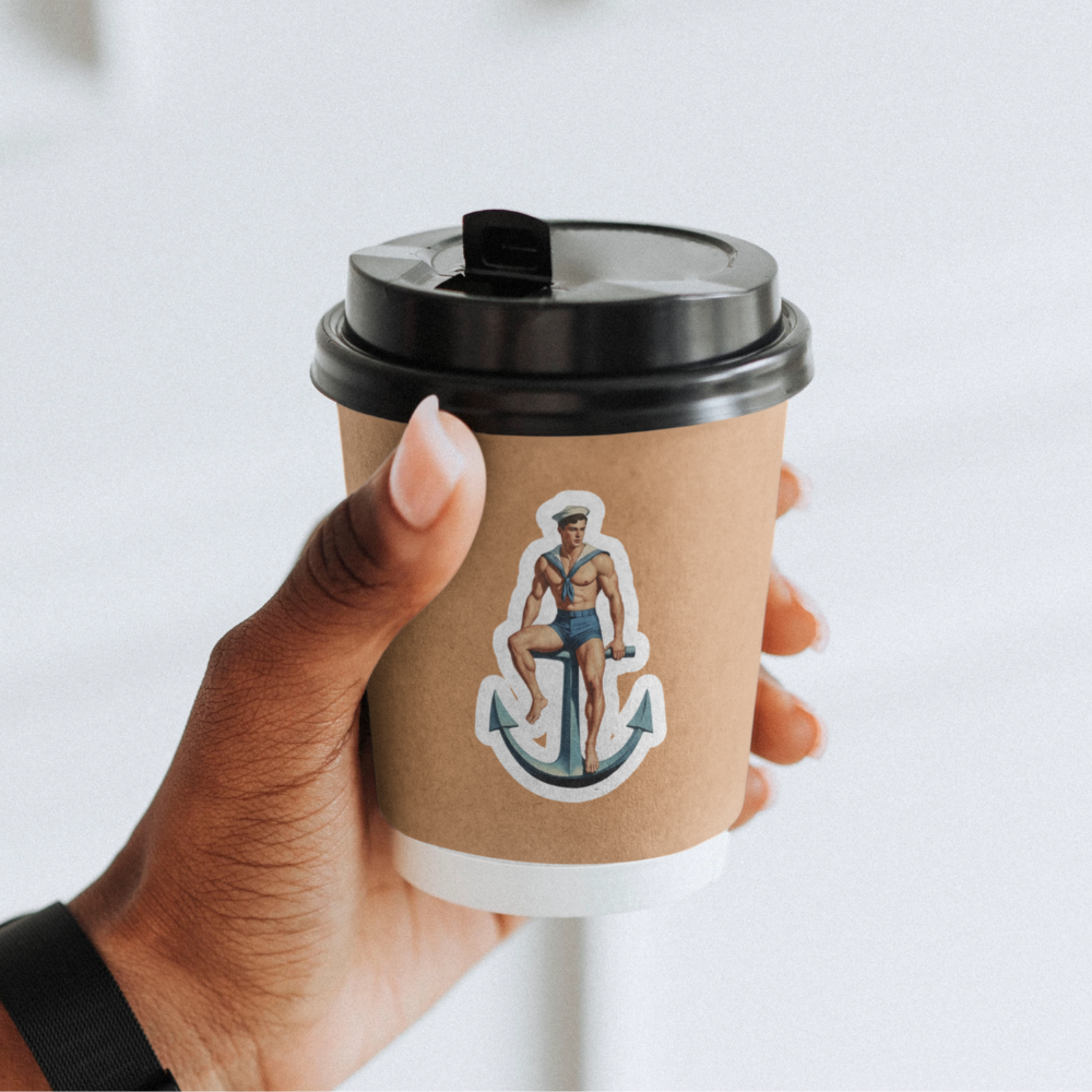 Hand holding a coffee cup with a sticker of a sailor on an anchor against a white background