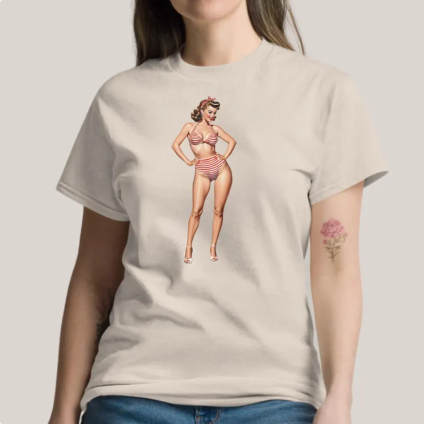 Beige t-shirt with a vintage-style graphic of a woman in a bikini on a plain background