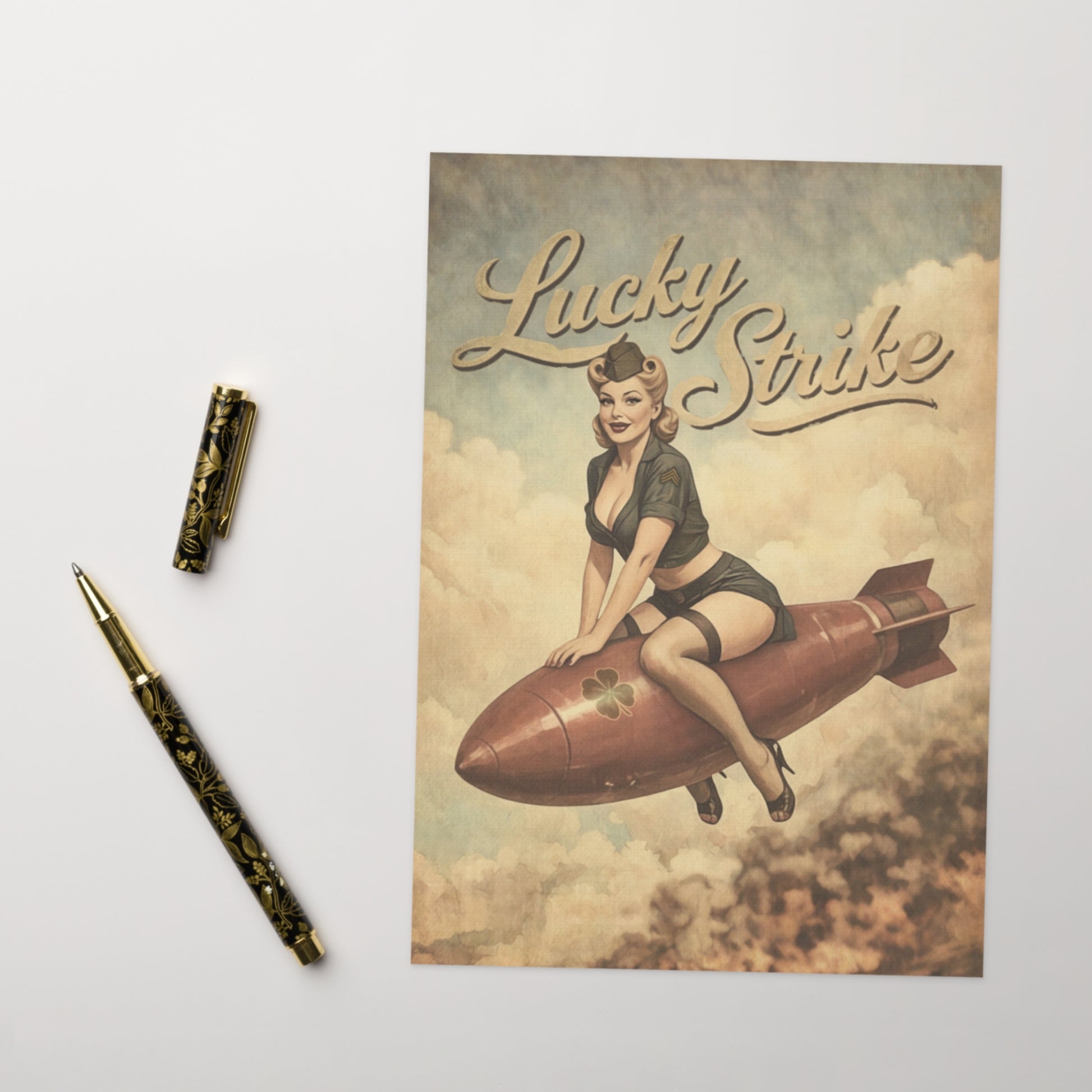 Vintage Lucky Strike cigarette pack with a woman on a rocket, accompanied by a pen on a light gray background.