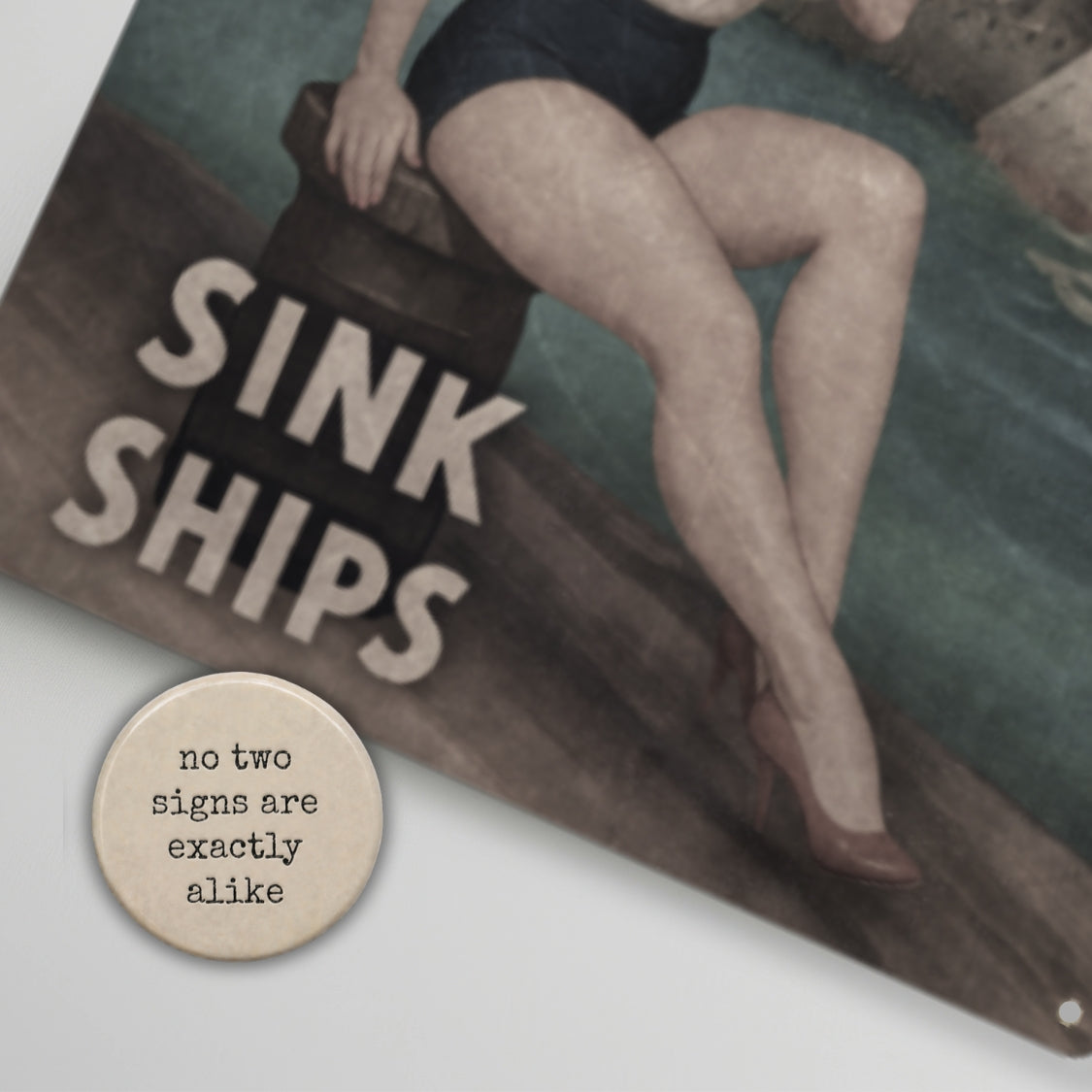 Artistic depiction of a person sitting on a log with 'Sink Ships' text, accompanied by a round metal sign with text.