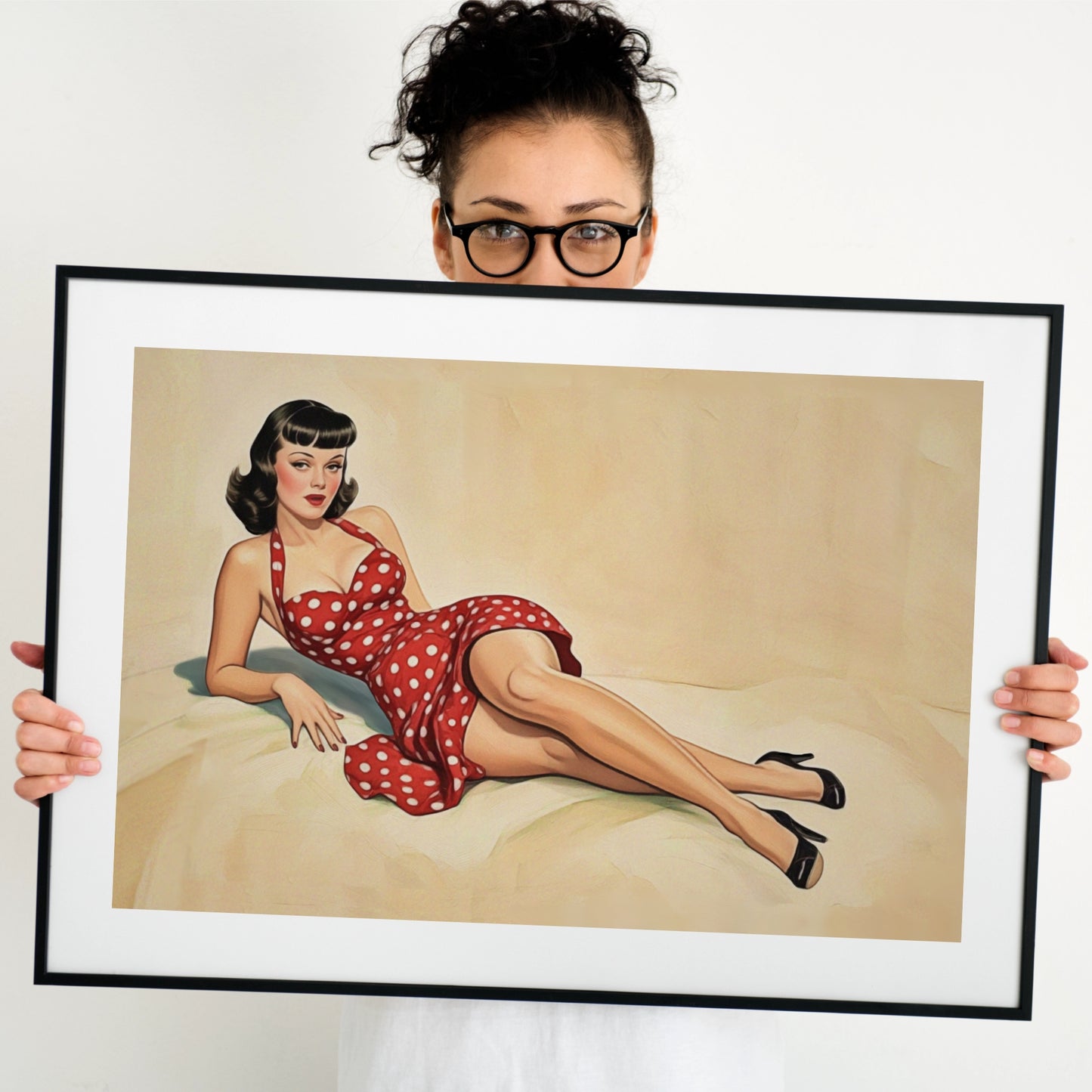 Person holding a framed artwork of a pinup woman in a red polka dot dress.