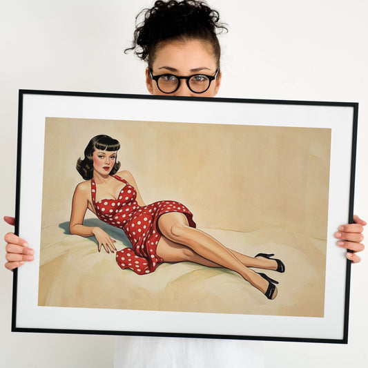 Person holding a framed artwork of a pinup woman in a red polka dot dress.