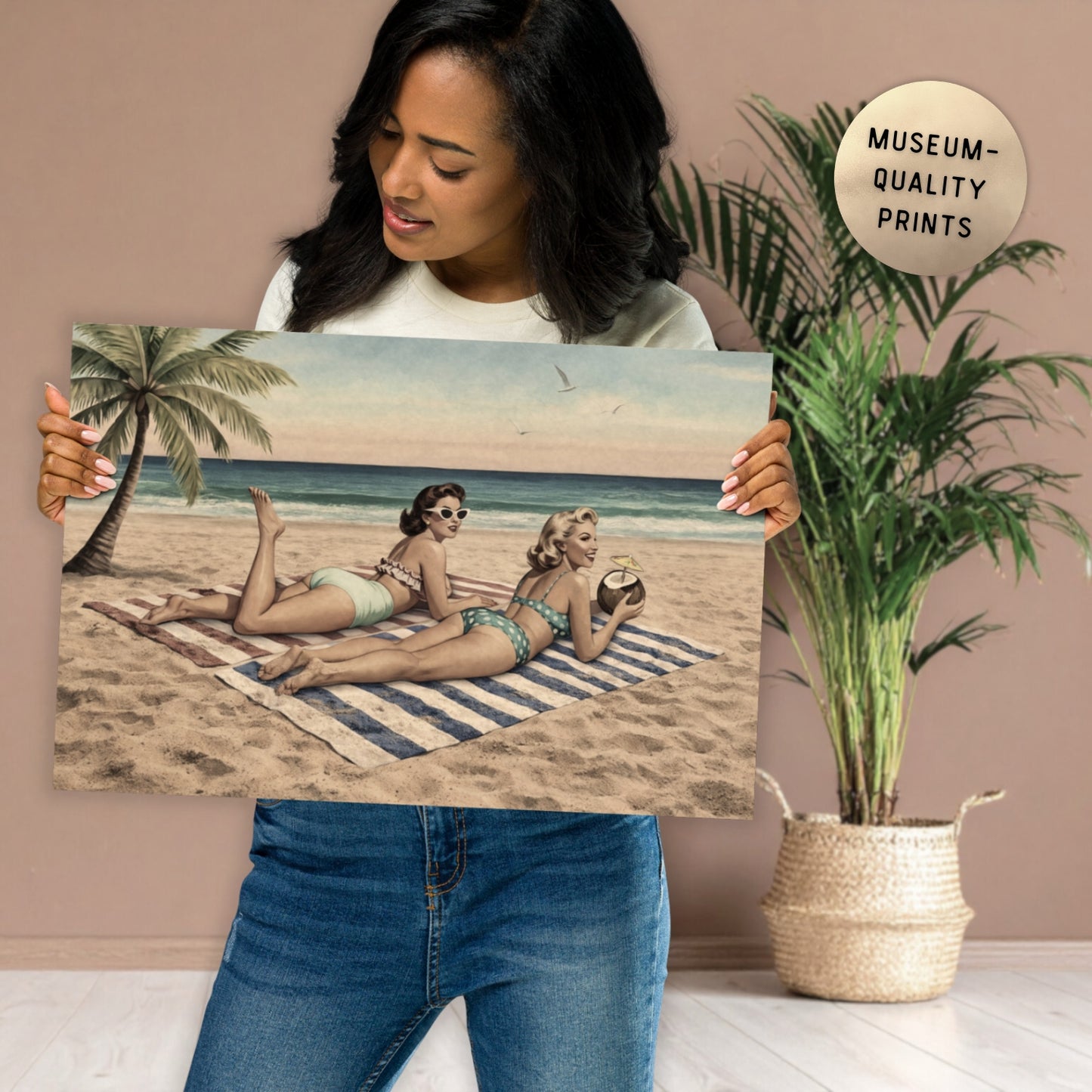 Woman holding a beach scene print with two women on a towel, palm tree, and ocean.