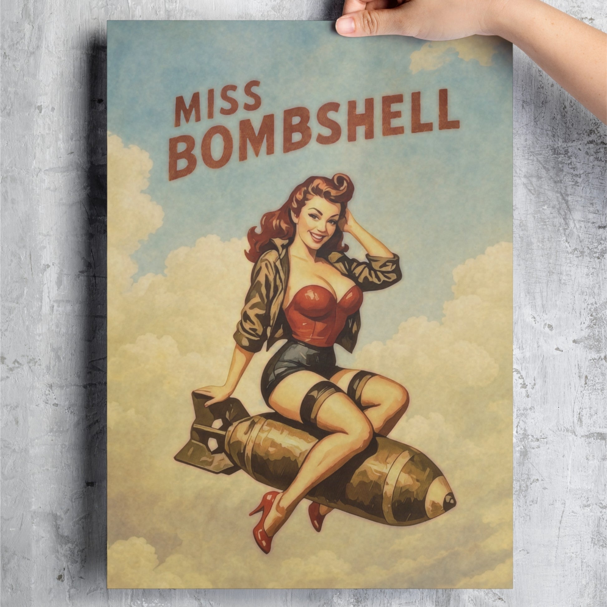 Poster of a woman sitting on a bomb with 'Miss Bombshell' text, held against a textured wall.