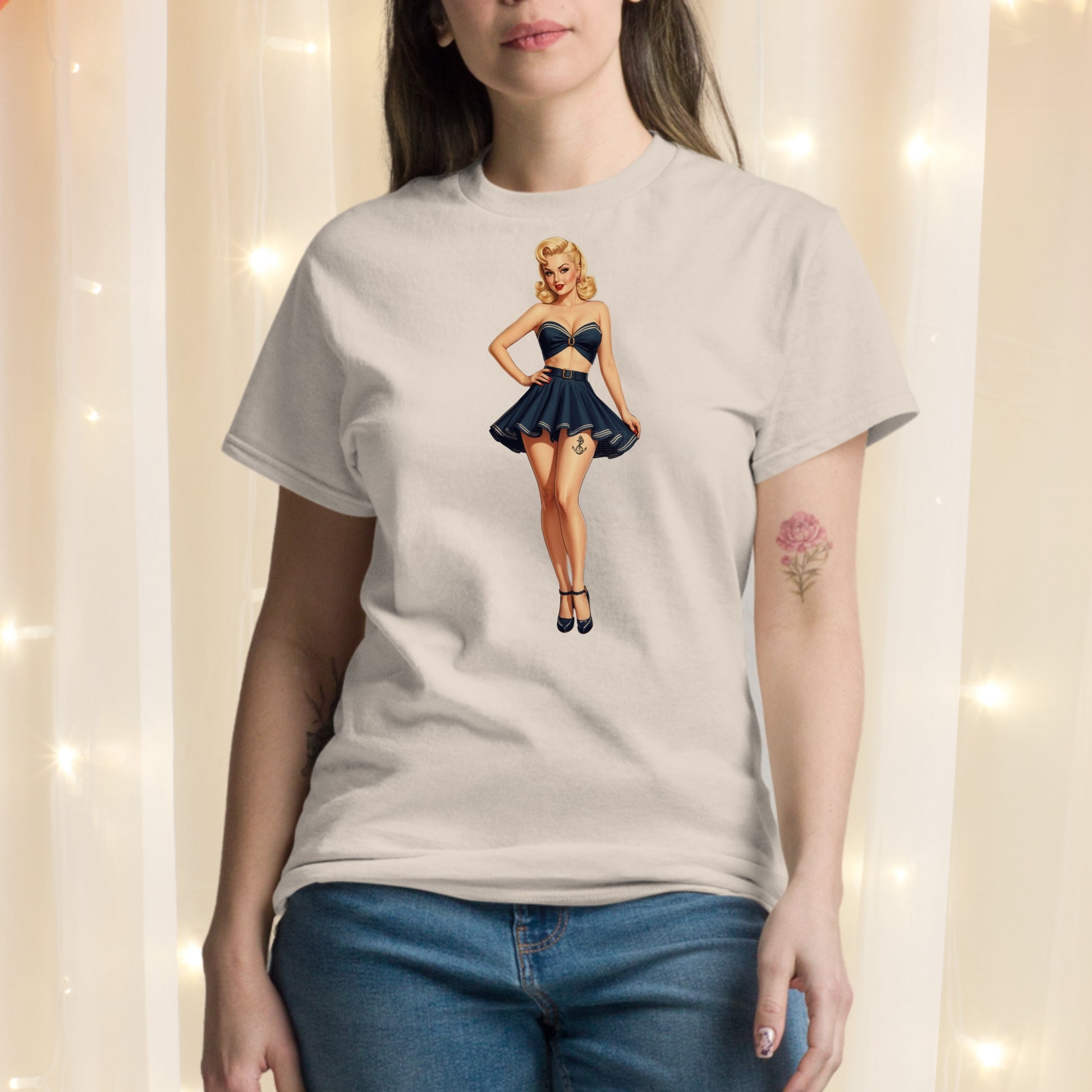 Person wearing a t-shirt with a graphic of a woman in a blue dress against a light background.