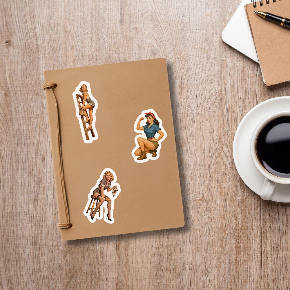 Notebook with stickers of a woman on a wooden surface next to a cup of coffee.