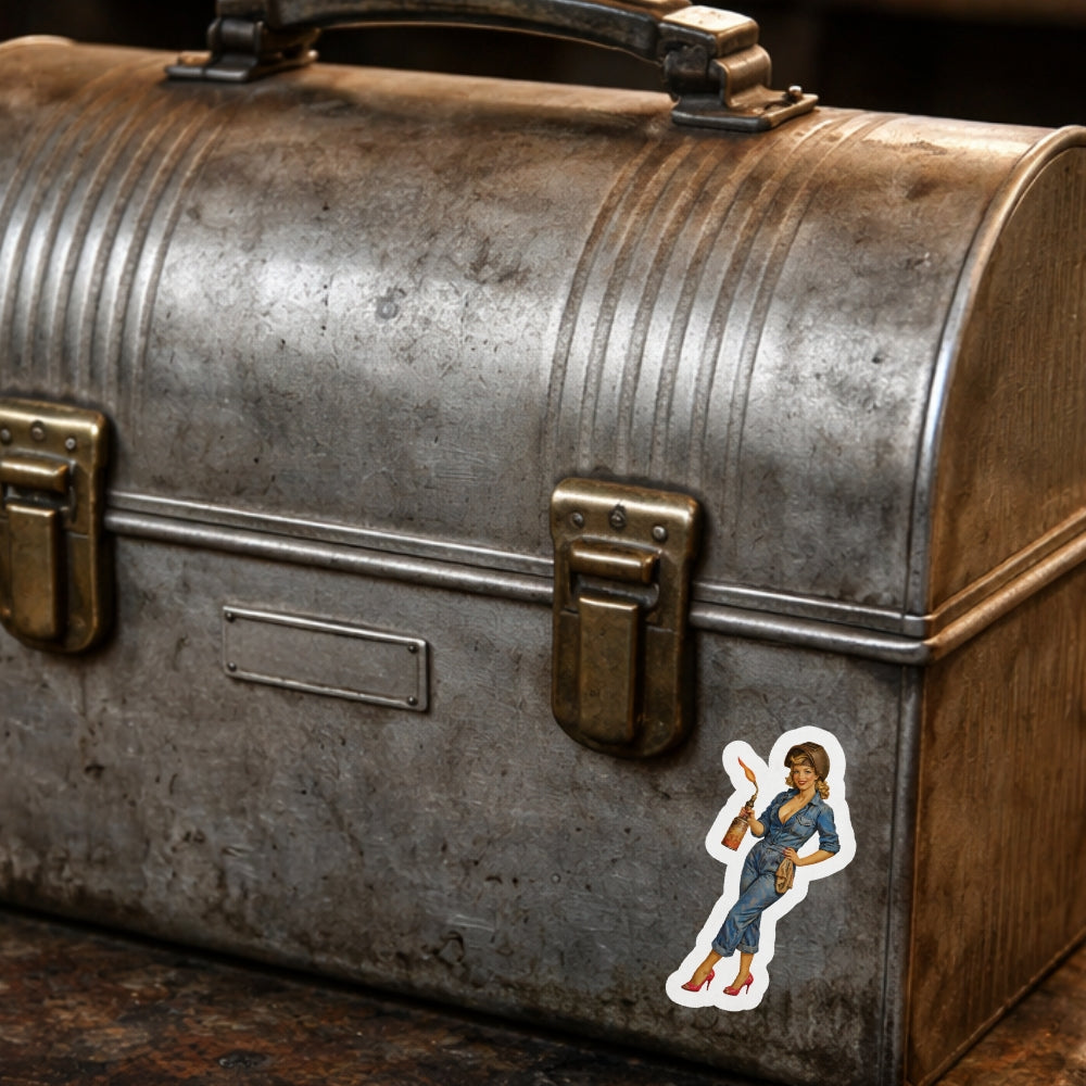 Vintage metal suitcase with a sticker of a woman on a wooden surface