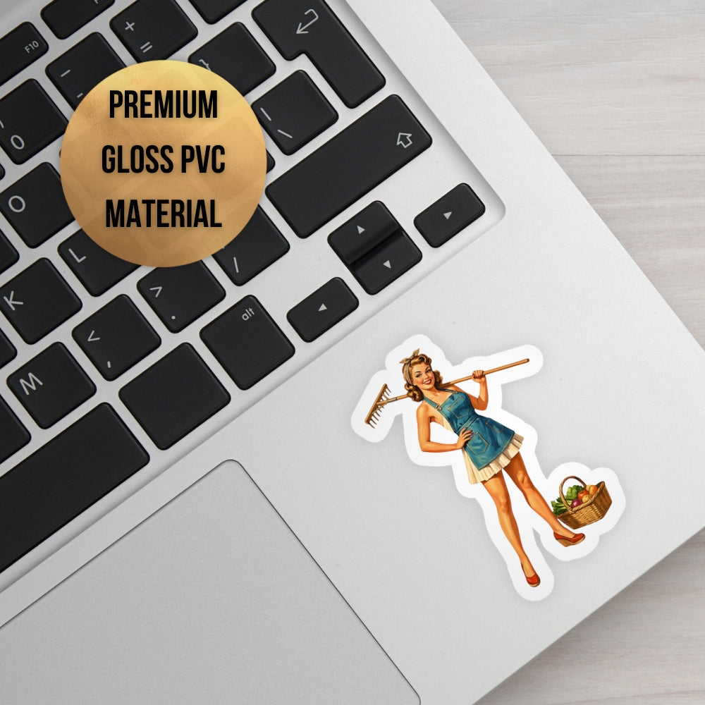Sticker of a woman holding a rake and basket on a laptop keyboard with 'Premium Gloss PVC Material' label.