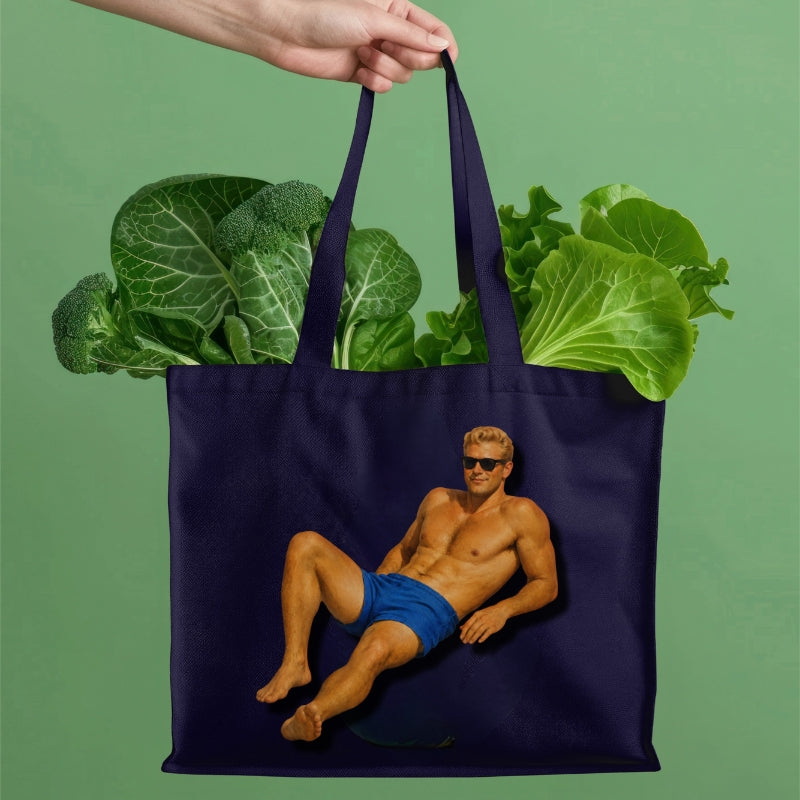 Navy tote bag with a graphic of a man in blue shorts holding fresh vegetables against a green background
