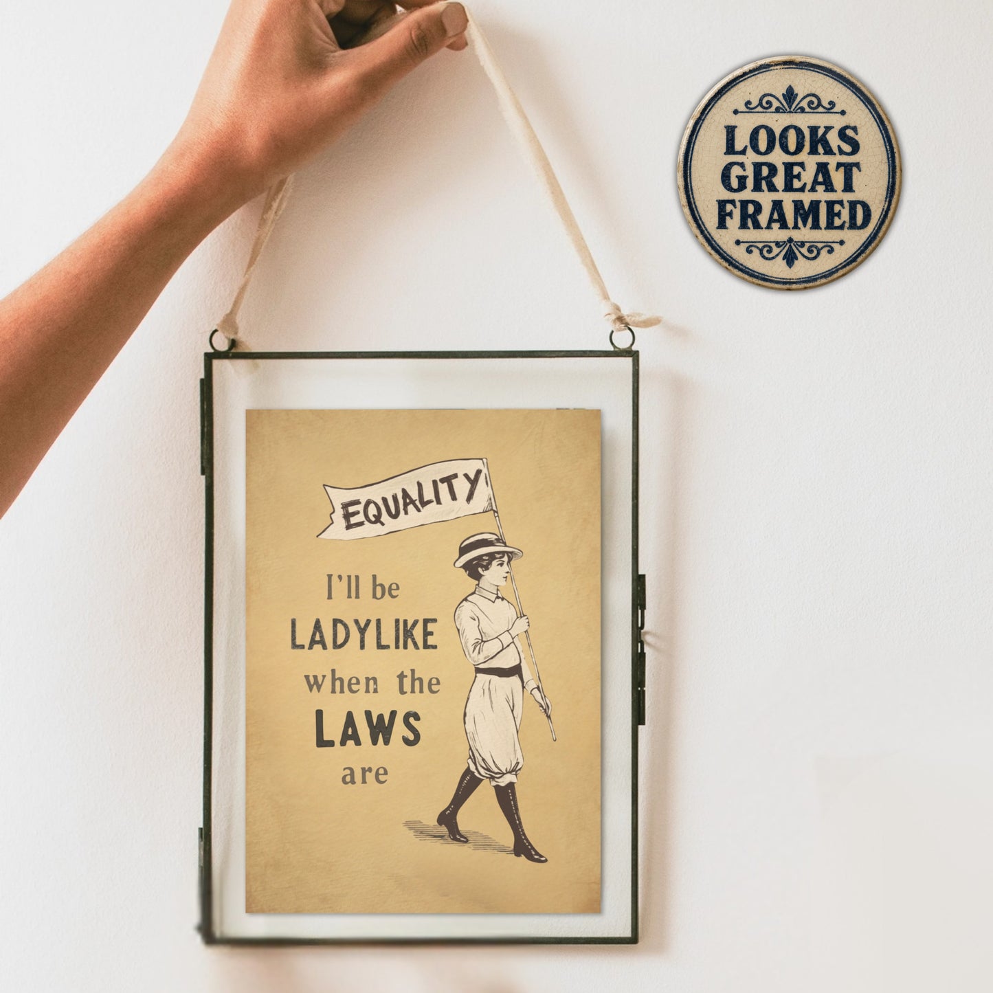 Framed feminism poster with a vintage-style illustration and text on a white wall.