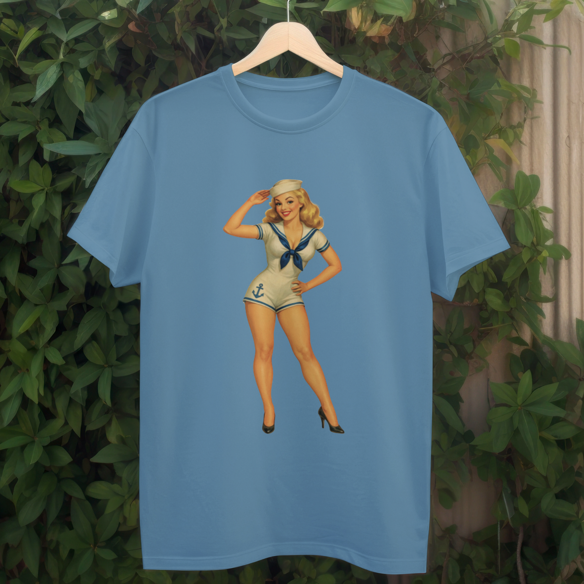 Blue t-shirt with a vintage-style graphic of a woman on a hanger against a green leafy background