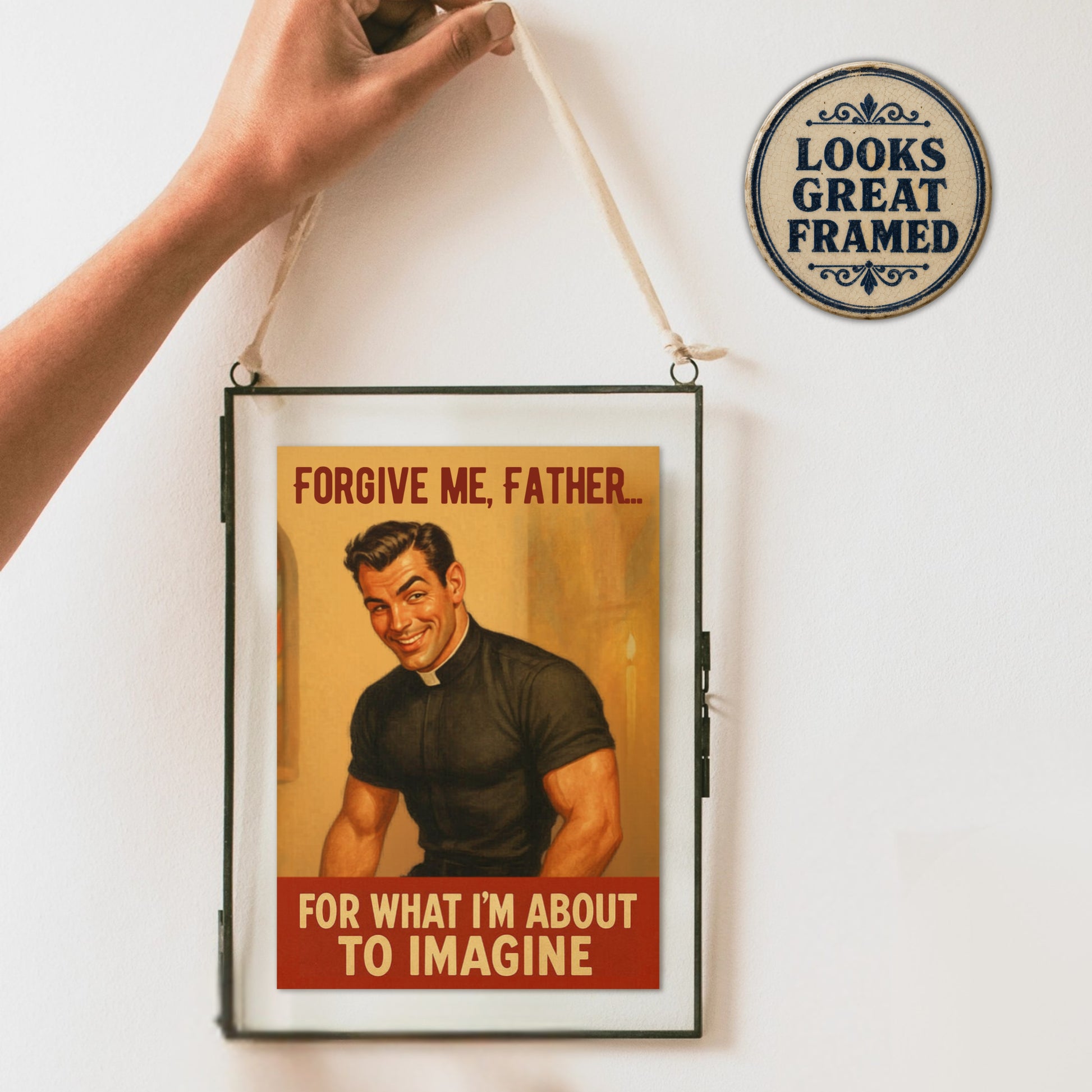 Framed male pinup boy card with a man in a suit and text, held by a hand against a white wall with a decorative sign.