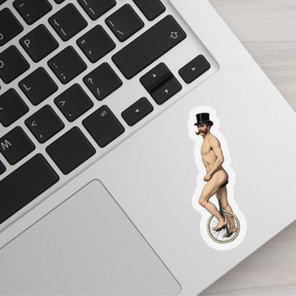 Laptop with a sticker of a man on a unicycle on a wooden surface